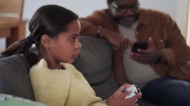 Concentrado Menina Africano Jogando Console Enquanto Seu Pai Olhando Para — Vídeo de Stock