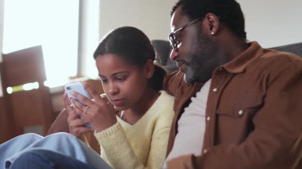 Θετικός Πατέρας Και Κόρη Κοιτάζουν Τηλέφωνο Και Μιλάνε Στον Καναπέ — Αρχείο Βίντεο