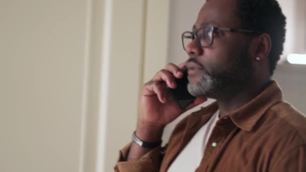 Homme Africain Sérieux Parlant Par Téléphone Regardant Montre Bracelet Maison — Video