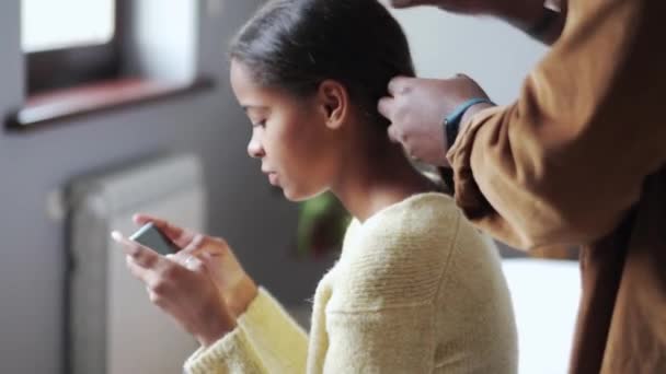 Afrikanischer Vater Sammelt Haare Seiner Tochter Beim Telefonieren Hause — Stockvideo