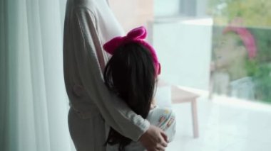 Kız odada annesinin gıdıklanmasına gülüyor.