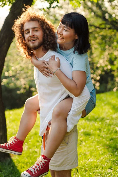 Happy Young Multiethnic Couple Cuddling Embracing Together Green Park Piggyback — Stock Photo, Image