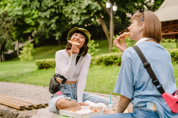 Πολυφυλετικές Δύο Γυναίκες Χαμογελώντας Και Τρώγοντας Πίτσα Ενώ Ξεκουράζονται Στο — Φωτογραφία Αρχείου