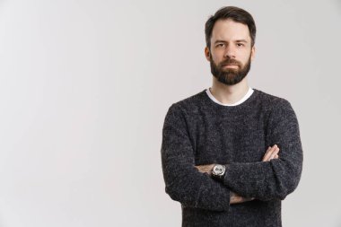 Beyaz, beyaz arka planda sakallı bir adam poz veriyor ve kameraya bakıyor.