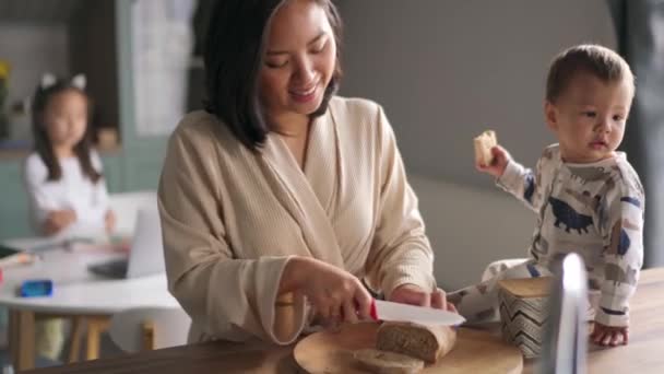 Glimlachen Aziatische Mam Snijdt Brood Met Haar Kinderen Keuken — Stockvideo