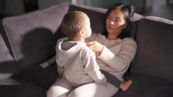 Koncentrerad Mor Dressing Och Prata Med Son Soffan — Stockvideo