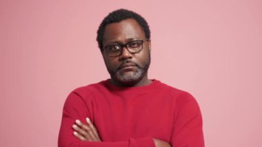 Düşünceli yetişkin Afrikalı adam pembe stüdyoda negatif cevap veriyor.