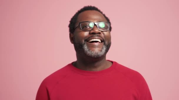 Lachende Volwassen Afrikaanse Man Kijkt Naar Camera Roze Studio — Stockvideo
