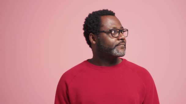 Positieve Volwassen Afrikaanse Man Kijkt Rond Toont Hallo Gebaar Roze — Stockvideo