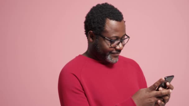 Lachender Erwachsener Afrikanischer Mann Telefoniert Rosa Studio — Stockvideo