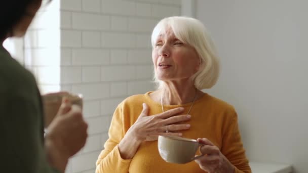 Веселая Зрелая Женщина Разговаривает Своей Подругой Пьет Чай Дома — стоковое видео