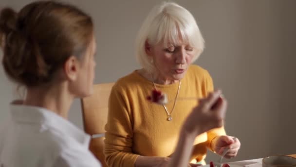 Femme Mûre Concentrée Mangeant Gâteau Parlant Avec Son Ami Maison — Video