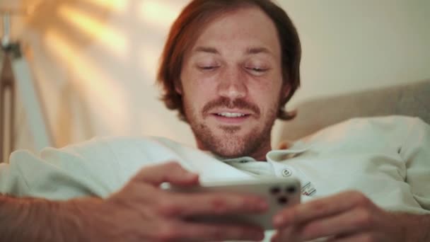 Lächelnder Langhaariger Mann Schaut Sich Video Telefon Während Hause Auf — Stockvideo