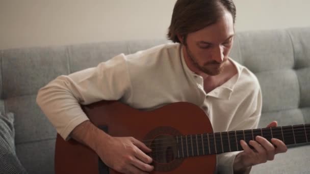 Serious Hombre Pelo Largo Aprende Tocar Guitarra Una Videolección Casa — Vídeo de stock