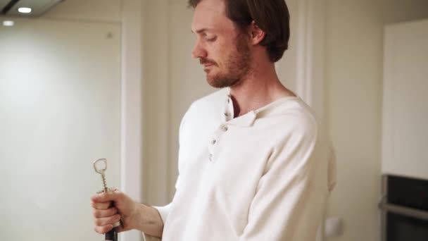 Θετικός Άντρας Μακριά Μαλλιά Που Ανοίγει Μπουκάλι Κρασί Στο Σπίτι — Αρχείο Βίντεο