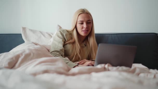 Mosolygó Szőke Dolgozik Laptop Nézi Oldalán Ágyban Otthon — Stock videók