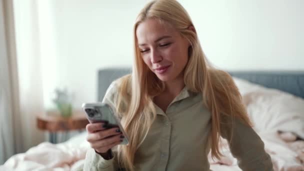 Positieve Blonde Vrouw Sms Telefoon Thuis — Stockvideo