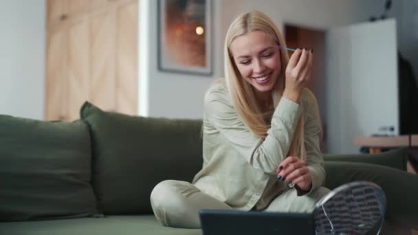 Uśmiechnięta Blondynka Czesająca Brwi Patrząca Tablet Domu — Wideo stockowe