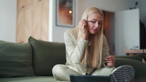 Pozytywne Blondynka Robi Makijaż Patrząc Tabletkę Domu — Wideo stockowe