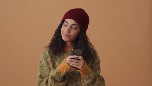 Positivo Africano Encaracolado Mulher Mensagens Texto Por Telefone Estúdio Bege — Vídeo de Stock