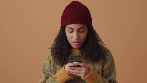 Enojado Africano Rizado Mujer Mensajes Texto Por Teléfono Estudio Beige — Vídeo de stock