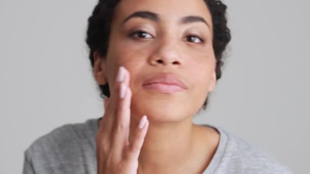 Uśmiechnięta Afrykanka Shircie Poprawia Makijaż Przed Kamerą Szarym Studio — Wideo stockowe