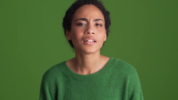 身穿绿色衬衫的非洲妇女在绿色工作室里没有听到手势 — 图库视频影像