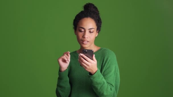 Mujer Africana Camisa Verde Volteando Cinta Por Teléfono Estudio Verde — Vídeo de stock