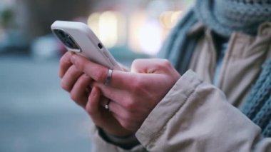 Erkek eller dışarıda telefonla yazı yazıyor.