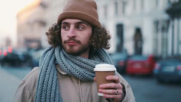 곱슬머리 남자가 커피를 마시고 둘러보고 있습니다 — 비디오