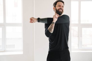 Gülümseyen esmer, beyaz adam spor giyim kuşamında el ele tutuşuyor.