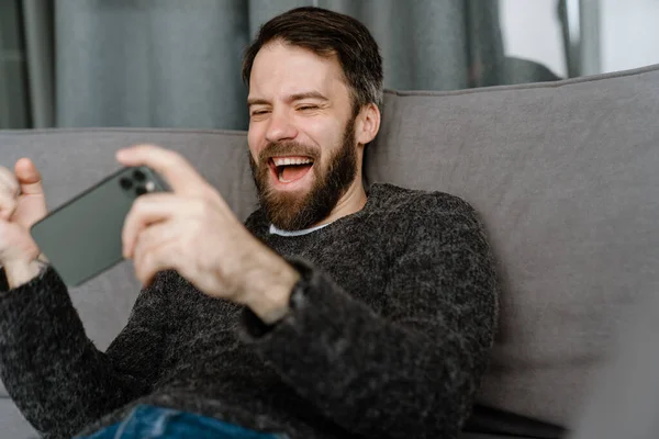 Bearded European Man Using Mobile Phone While Sitting Sofa Home — Stock Photo, Image