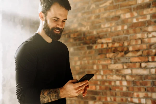 Mid Aged Smiling Bearded Sportsman Wearing Smartwatch Standing Indoors Holding — Stock Photo, Image