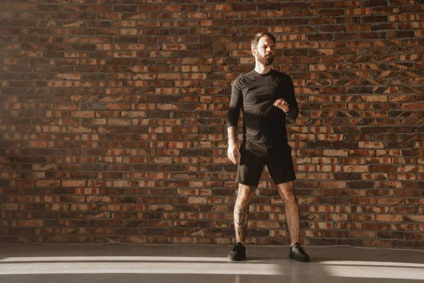 Kendinden emin orta yaşlı beyaz sporcu, parlak bir odada zıplıyor.