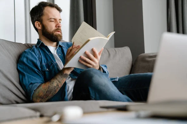 Bärtiger Mann Schreibt Notizen Während Hause Mit Laptop Auf Dem — Stockfoto