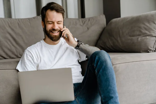 Szakállas Férfi Mobilon Beszél Laptoppal Dolgozik Miközben Otthon Padlón — Stock Fotó