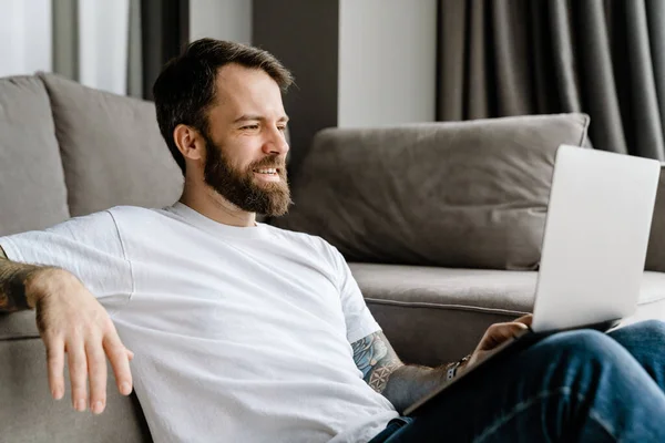 Homem Europeu Barbudo Trabalhando Com Laptop Enquanto Sentado Chão Casa — Fotografia de Stock