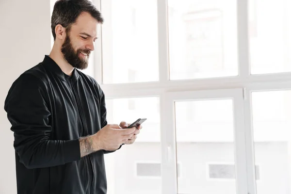 Smiling Young Brunette White Man Sportswear Standing Indoors Looking Mobile — Stock Photo, Image