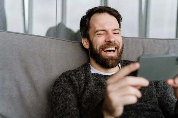 Homem Europeu Barbudo Usando Telefone Celular Enquanto Sentado Sofá Casa — Fotografia de Stock