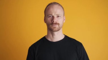 Pozitif adam sarı stüdyoda başını sallıyor.