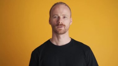 Sarı stüdyoda dalgın dalgın titreyen bir adam.