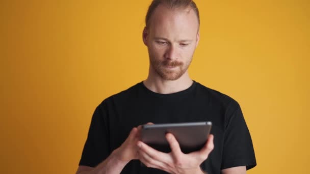 Súlyos Férfi Gépelés Tabletta Sárga Stúdióban — Stock videók