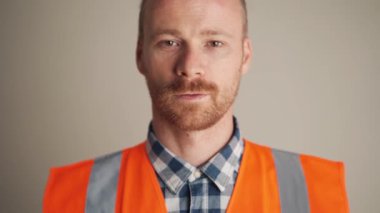 Neşeli mühendis gri stüdyoda kaskını taktı.