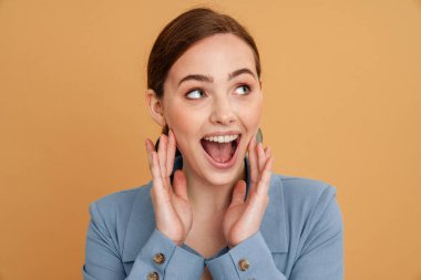 Genç kızıl, sarı arka planda izole edilmiş kameraya el kol hareketi yapan ve çığlık atan kadını heyecanlandırıyor.