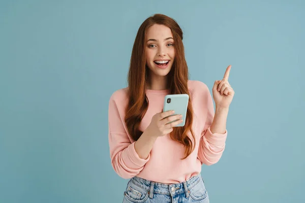 Молода Імбирна Жінка Спрямовує Палець Вгору Використовуючи Мобільний Телефон Ізольовано — стокове фото