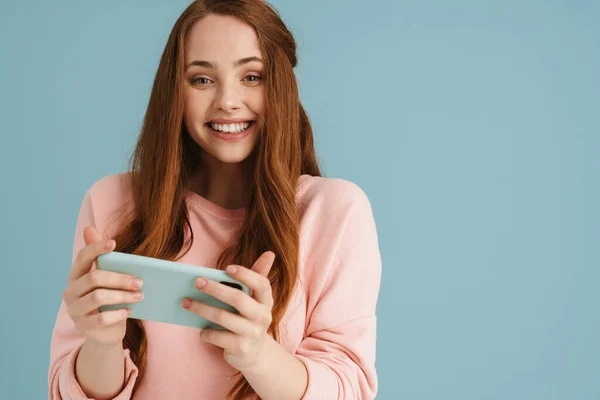 Молода Імбирна Жінка Посміхається Використовує Мобільний Телефон Ізольовано Синьому Фоні — стокове фото
