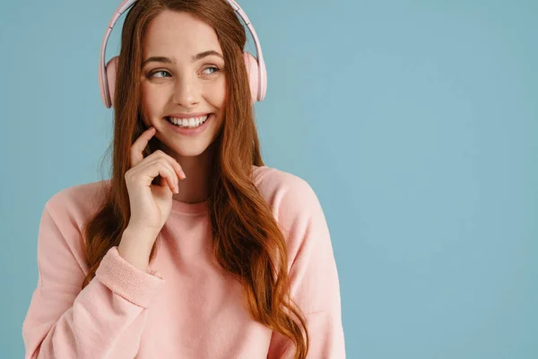 Ung Ingefära Kvinna Ler Medan Lyssnar Musik Med Hörlurar Isolerade — Stockfoto