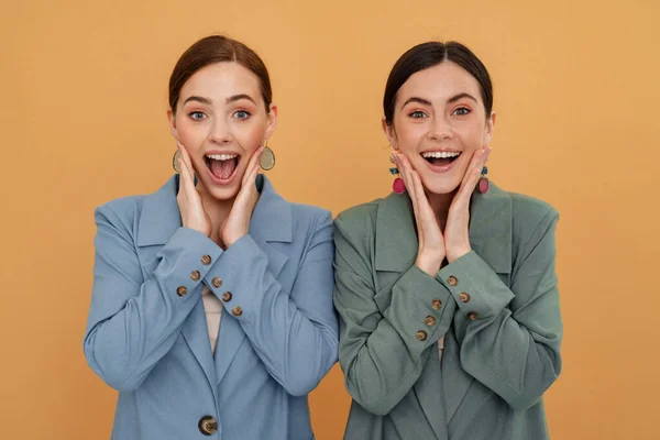 Dwie Młode Kobiety Kurtkach Uśmiechnięte Krzyczące Kamery Odizolowane Żółtym Tle — Zdjęcie stockowe