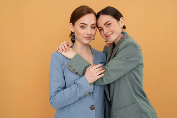 Jonge Twee Vrouwen Dragen Jassen Knuffelen Glimlachen Camera Geïsoleerd Gele — Stockfoto