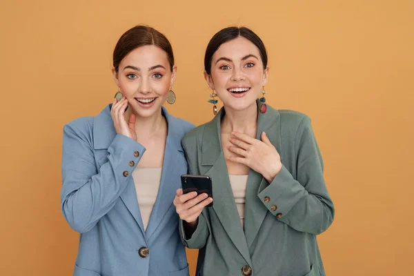 Mladé Dvě Ženy Úsměvem Při Použití Mobilního Telefonu Izolované Přes — Stock fotografie